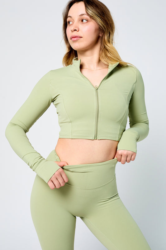 Woman wearing ICONIC Sculpting Leggings and jacket in green pisatchio