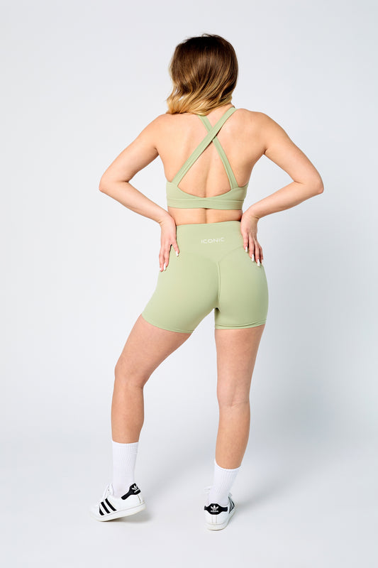 Person wearing a green sports outfit with a white background
